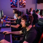 Engaged players in a vibrant gaming lounge showcasing FAFA 828 gaming experience with high-end setups.